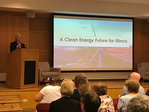 Pictured: Walker (top left) speaks to attendees of the Clean Energy Town Hall about the status of green legislation in Springfield.